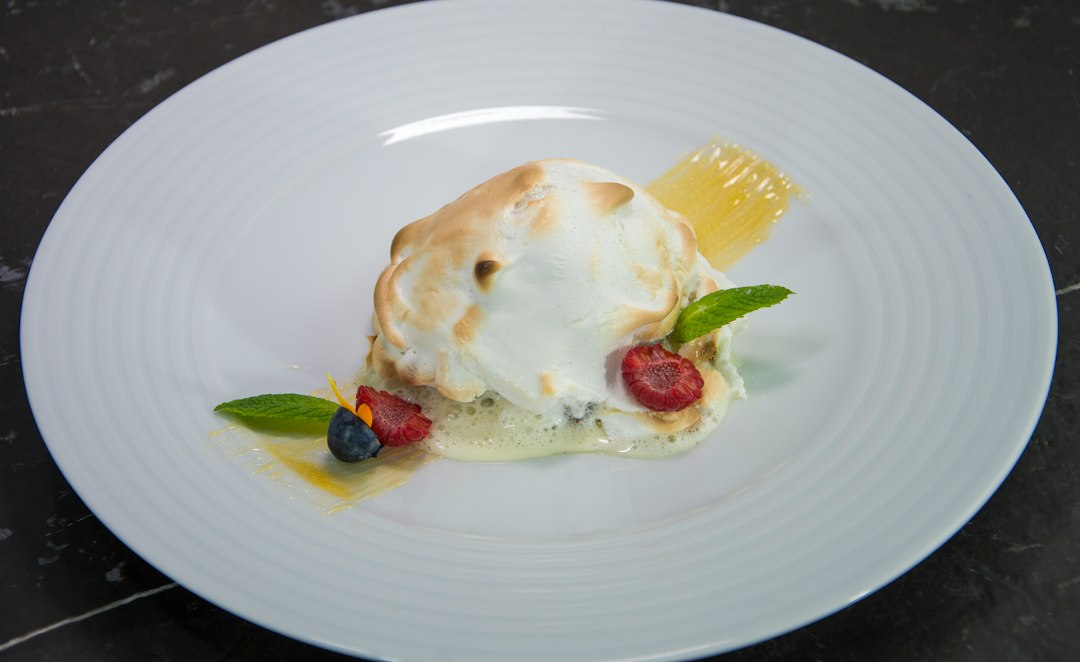 Baked Alaska dessert with meringue, berries, and mint.