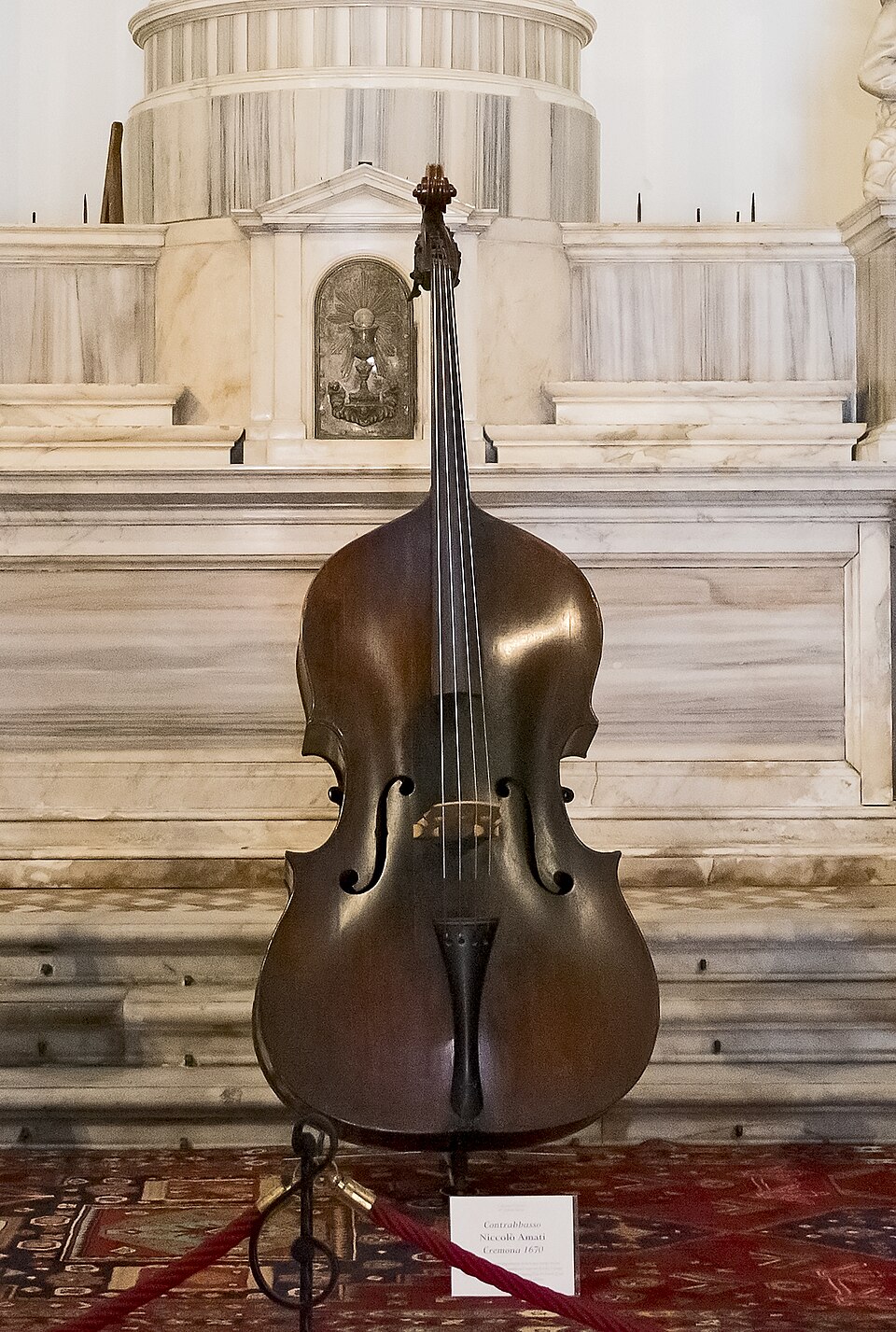 A double bass made by Niccolò Amati in Cremona in 1670, on display in a marble interior.