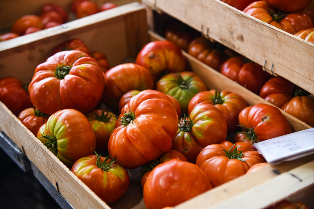 Heirloom tomatoes in wooden crates at a market.