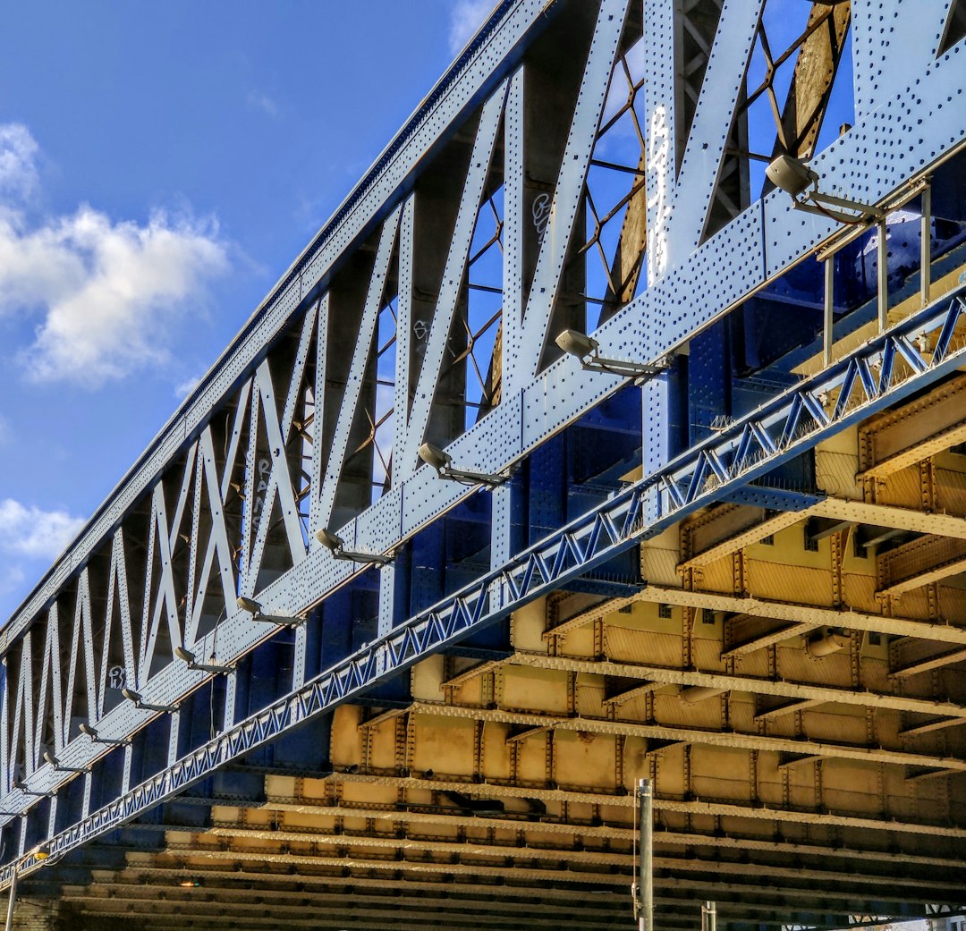 Thiccc steel I-beams under a bridge, embodying unapologetic strength.