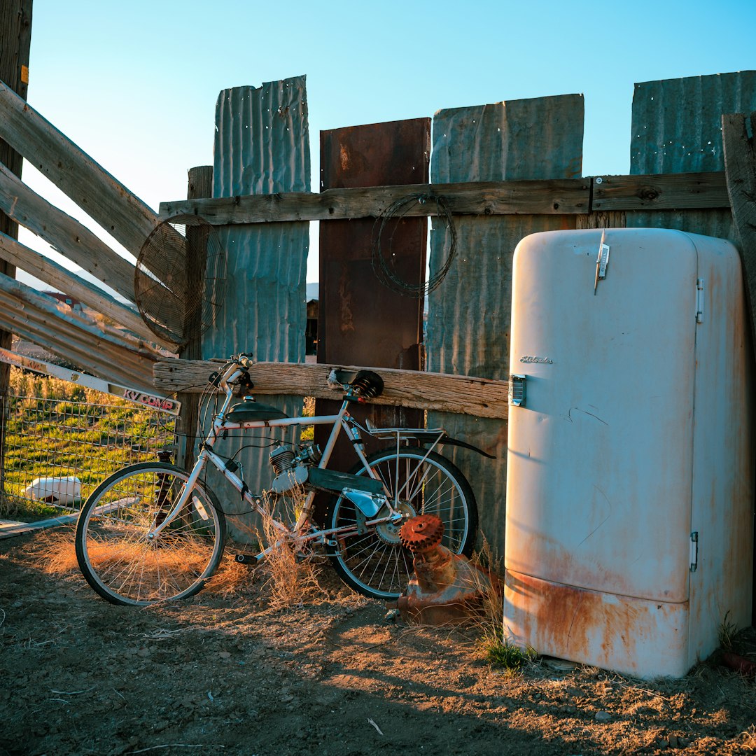 Retro refrigerator next to an old bike.