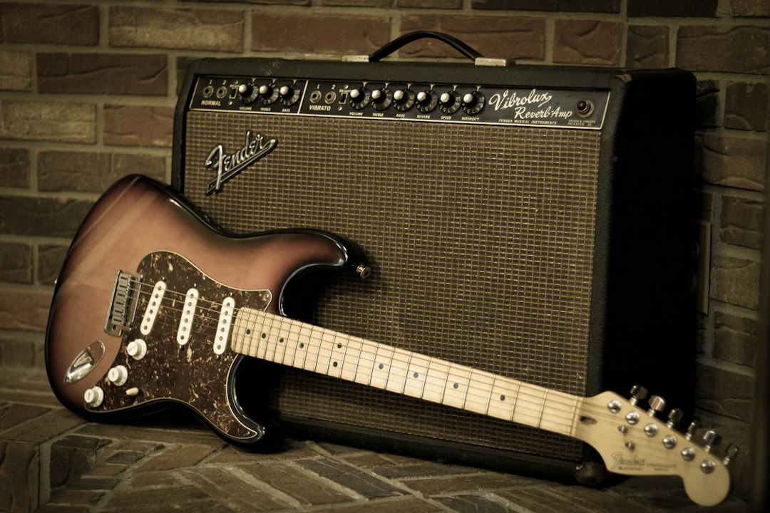Fender Stratocaster guitar leaning against a Vibrolux Reverb amplifier.