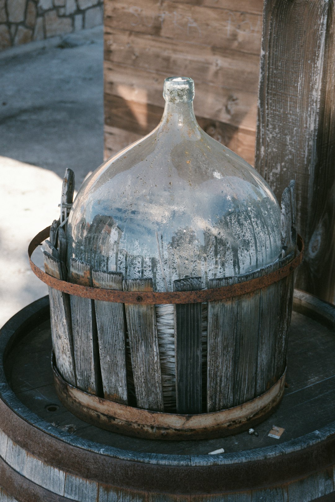 Vintage glass demijohn in a wooden basket.