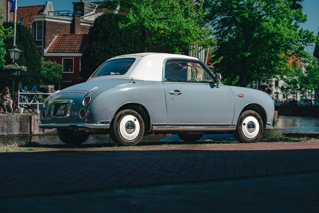 Nissan Figaro parked near a canal.