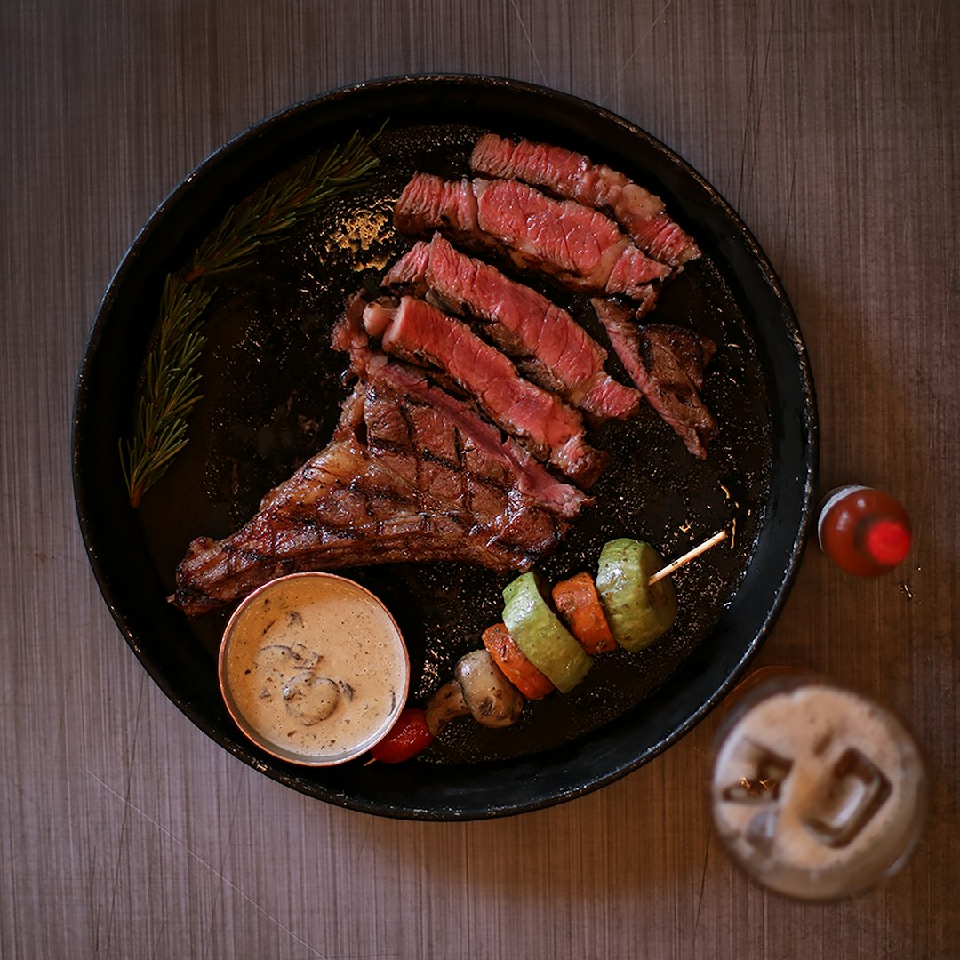 A prime rib roast at full carving weight, viewed from the side in raking light.