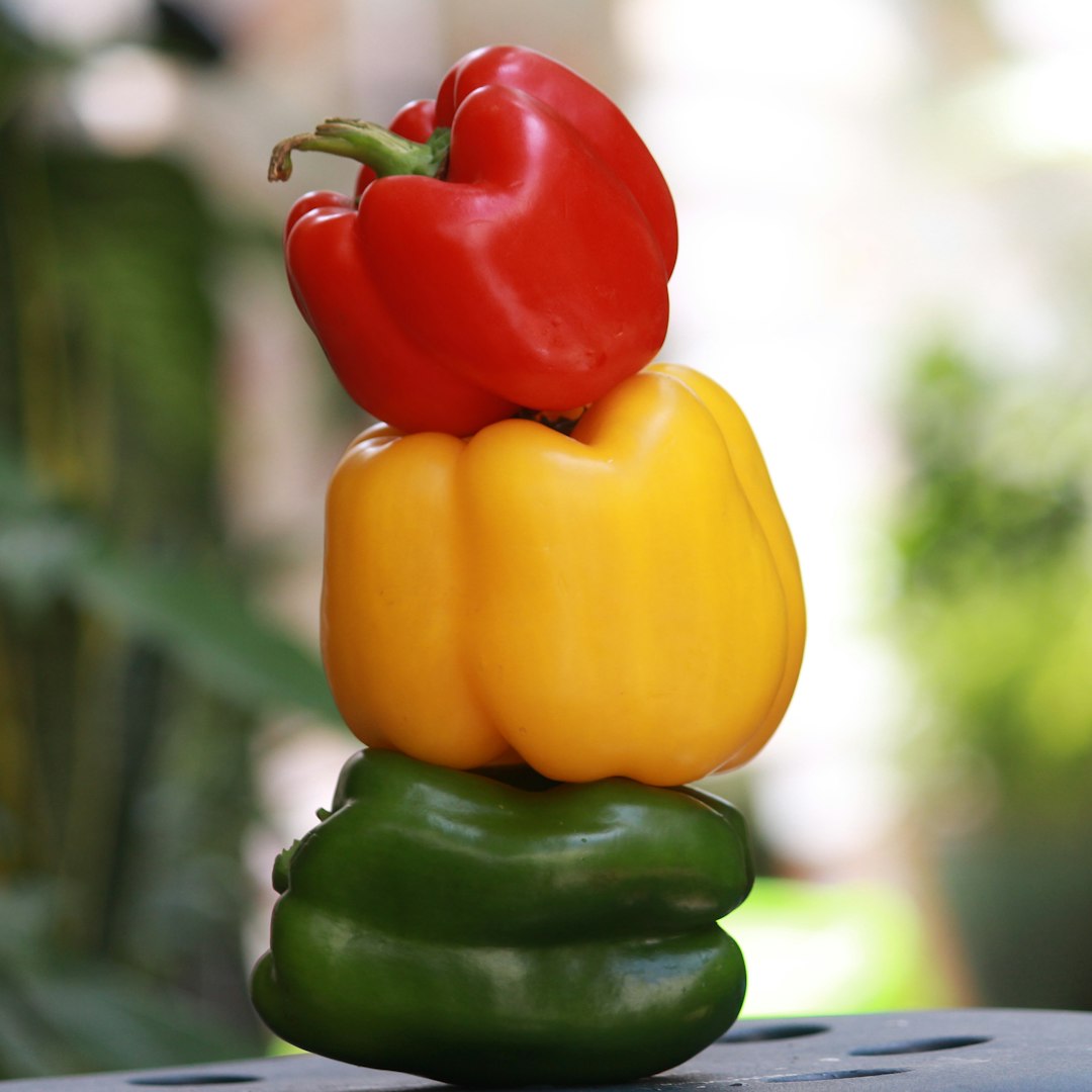 Stack of red, yellow, and green bell peppers.