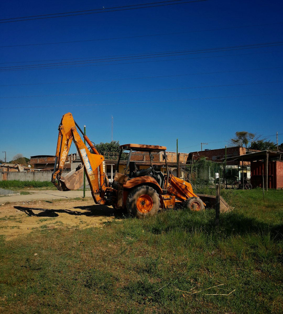 The backhoe loader in its natural habitat, asserting dominance over open fields.