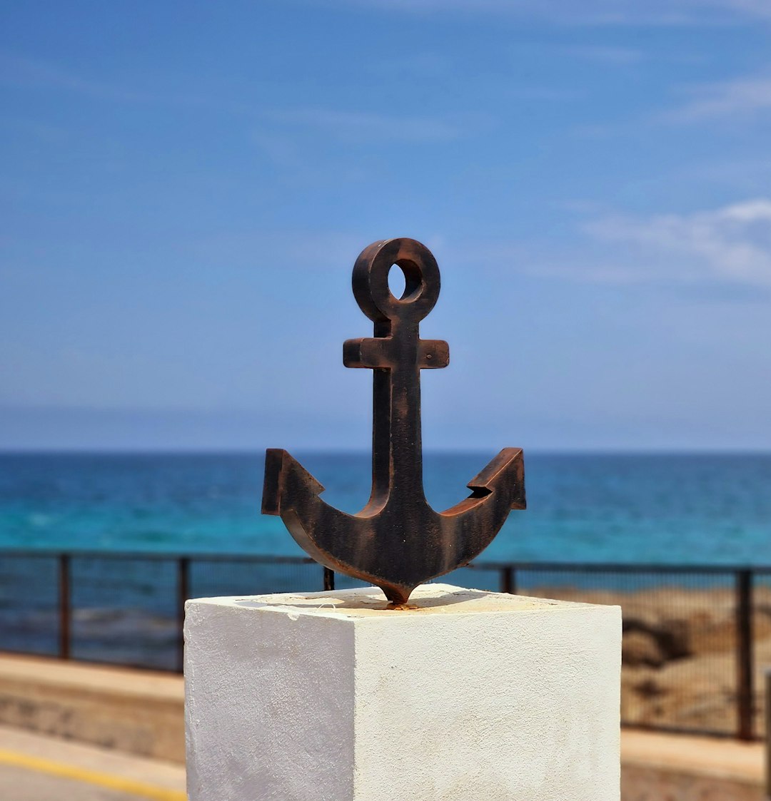 A venerable ship's anchor, resting on the dock with the unhurried confidence of an object nobody has ever asked to move by