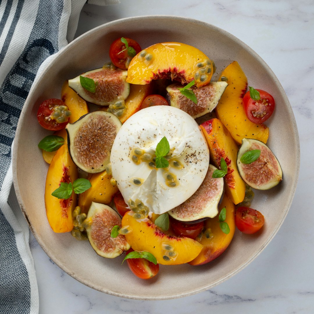 Burrata with fruits in a bowl.