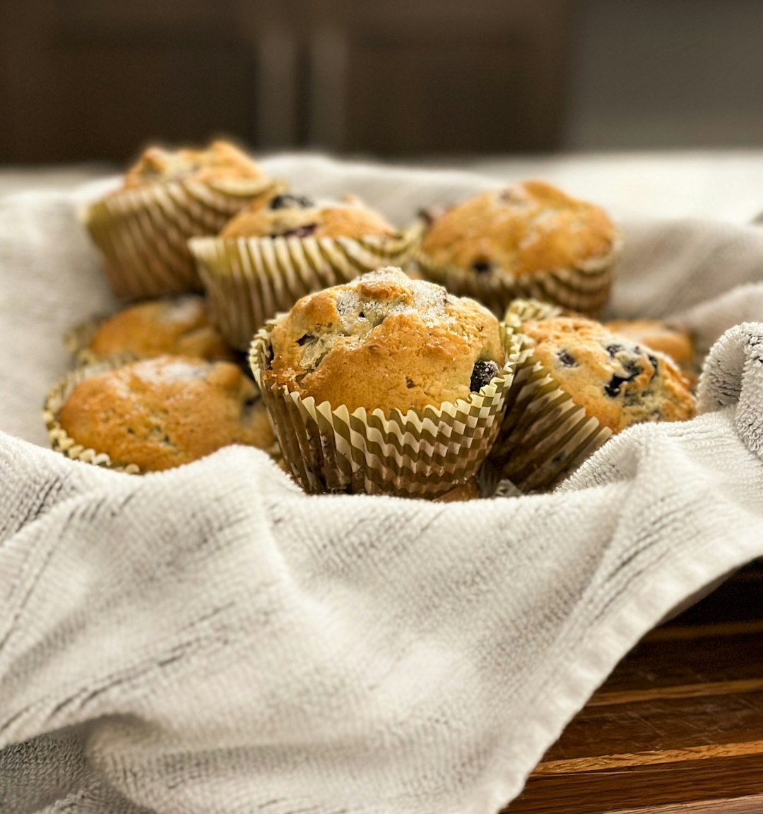 Basket of blueberry muffins on a wood board.