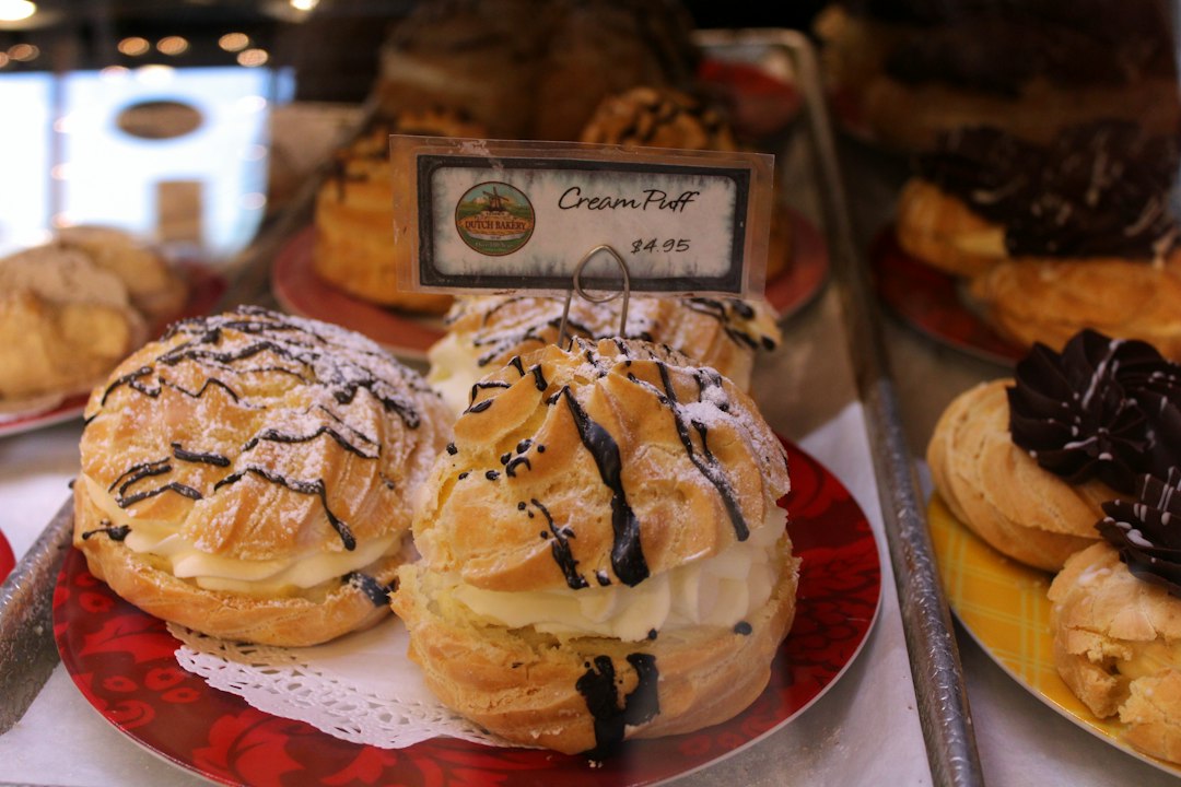 Display of cream puffs in a bakery case.