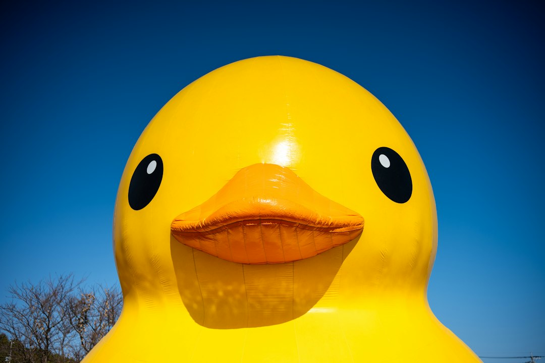 Giant yellow rubber duck against a blue sky.