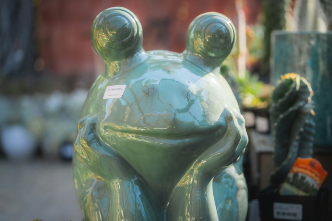 Glossy green ceramic frog statue.