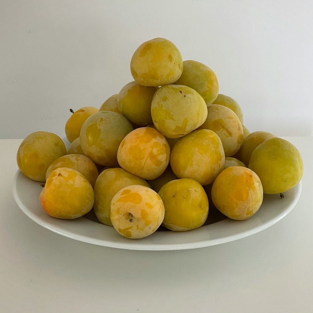 A plate of yellow plums, piled high.