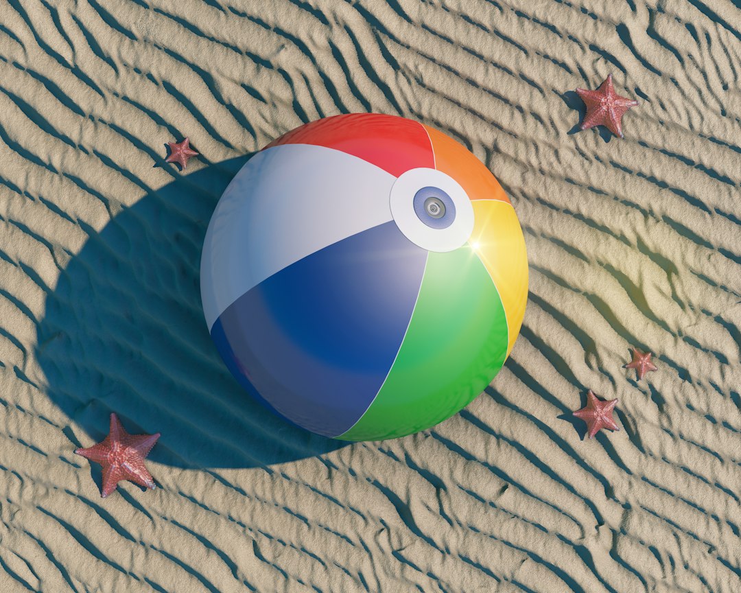 Giant inflatable beach ball on sand.