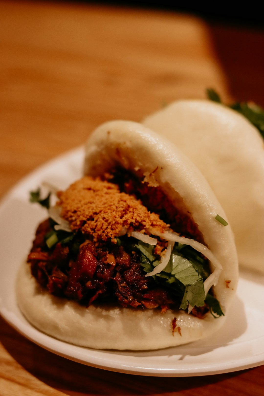 Bao with generous filling on a plate.