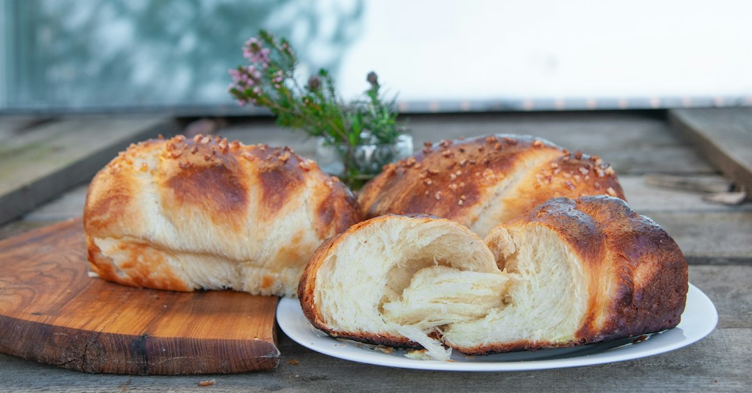 A plate of brioche buns on a wooden table.