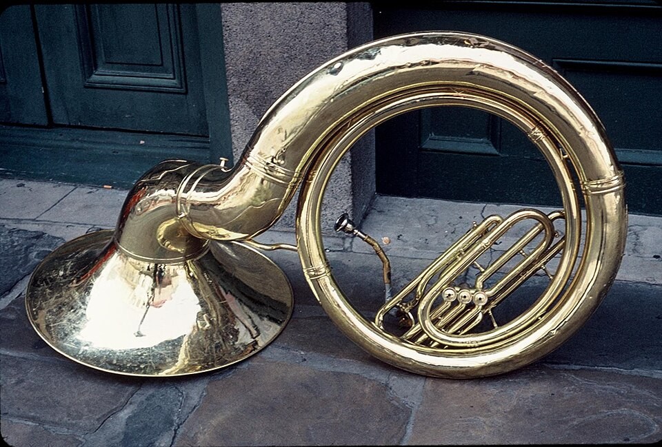 A sousaphone resting on a sidewalk in the French Quarter, New Orleans.