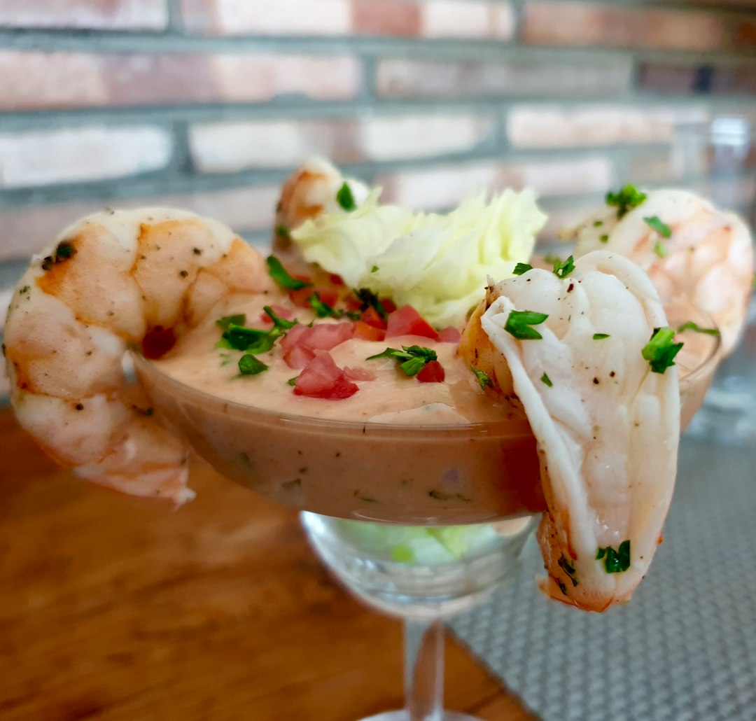 Jumbo shrimp on a martini glass with cocktail sauce.