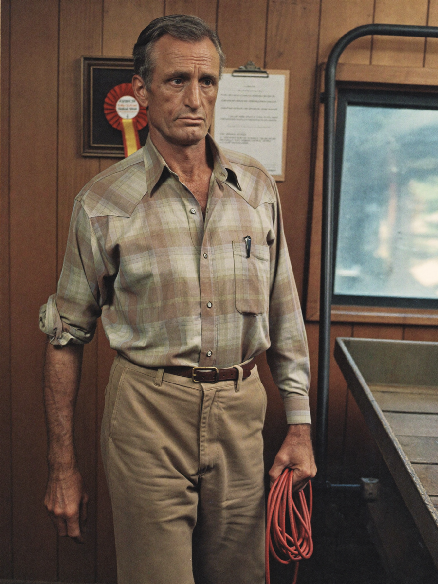 Jon, Circulation Manager, around 50, thin runner's build, plaid western shirt, holding a coiled lead rope at the loading dock
